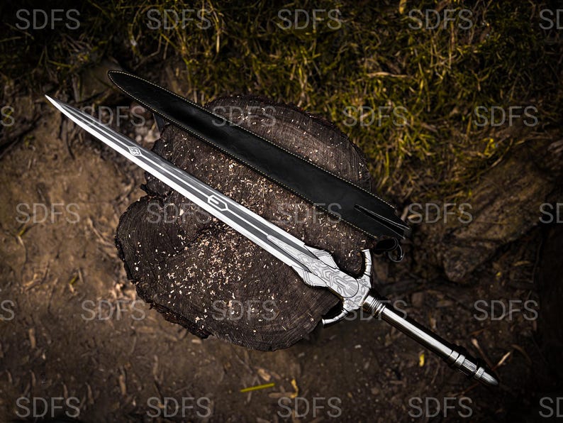 May include: A detailed image of a silver sword with a decorative handle and a black leather sheath. The sword is resting on a wooden surface, showcasing its intricate design and craftsmanship. The blade has a length of approximately 30 inches.