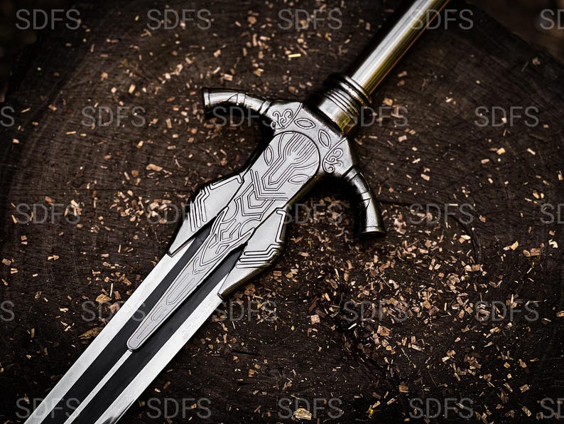 May include: A detailed, silver-colored sword with intricate designs on the hilt and blade. The sword features a black stripe down the center of the blade. The weapon rests on a dark, textured wooden surface.