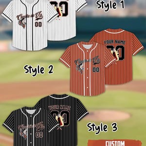 May include: Baseball jerseys in three styles: white with black stripes, red with white stripes, and black with white stripes. Each jersey features a team logo, the number "00", and the text "YOUR NAME" with the number "30" on the back. The text "CUSTOM NAME & NUMBER" is also present.