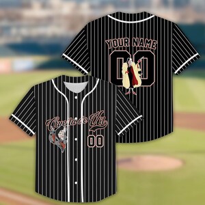 May include: Black and white pinstripe baseball jersey with white trim. The front features the text "Cruella de Vil" and a cartoon image. The back has "YOUR NAME" and the number "00".