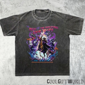 May include: Dark gray t-shirt with a graphic of a skeleton cowboy riding a horse, surrounded by purple and blue energy. Text on the shirt reads "THE NIGHT THE SKELETONS CAME TO LIFE". The shirt has a vintage, washed look.