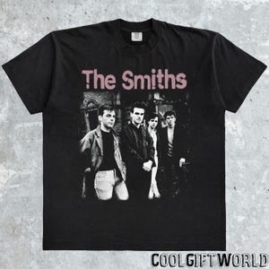 May include: Black t-shirt featuring the band "The Smiths" with a faded pink text. The image on the shirt shows the band members in black and white. The text "COOLGIFTWORLD" is at the bottom of the shirt.