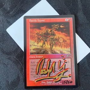 May include: A Magic: The Gathering trading card titled Battle Hymn with a red border and illustration of soldiers marching. The card features a prominent black and yellow ink signature across the centre and the handwritten numbering 15/50 in red.