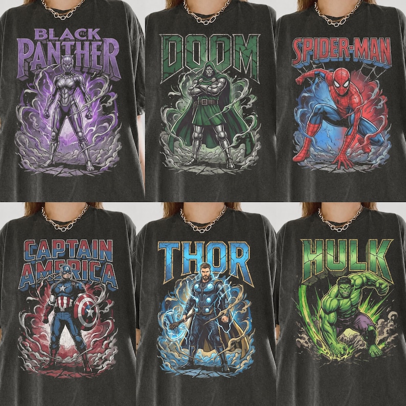 May include: A collection of six black t-shirts featuring graphic prints of Marvel characters including Black Panther, Doctor Doom, Spider-Man, Captain America, Thor, and Hulk, each with their respective names in bold, colourful lettering.