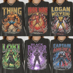 May include: A collection of six charcoal grey t-shirts featuring graphic prints of Marvel characters including The Thing, Iron Man, Logan Wolverine, Loki, Black Panther, and Captain America, each with bold text and dynamic action scenes.