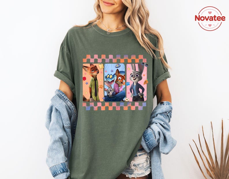 Może przedstawiać: Zielona koszulka z nadrukiem postaci z animowanego filmu Zwierzogr&oacute;d. Grafika jest obramowana wzorem w kratkę w kolorze r&oacute;żowym, pomarańczowym i fioletowym. Koszulka ma kr&oacute;tkie rękawy i luźny kr&oacute;j.