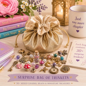 May include: A gold metallic drawstring pouch filled with assorted charms, beads, and miniature treasures. The collection includes metal keys, a clock, a tree, a dragonfly, a star, and mushroom figures, alongside a small glass bottle of beads.