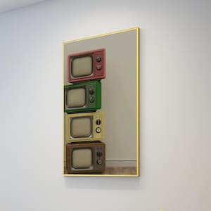 May include: A framed print featuring a stack of four vintage-style televisions in shades of red, green, yellow, and brown. The TVs have rounded corners and knobs, with a gold frame surrounding the image.