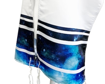 Può includere: Sciarpa da preghiera bianca con un design galattico blu e nero sul fondo. Lo scialle ha strisce bianche e testo in ebraico sul colletto. Lo scialle è drappeggiato su un manichino bianco.
