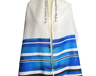 Può includere: Un tallit bianco e blu, scialle di preghiera ebraico, con strisce blu acquerello. La parte superiore è bianca con testo ebraico. La sezione inferiore presenta strisce orizzontali in tonalità blu, nere e bianche.