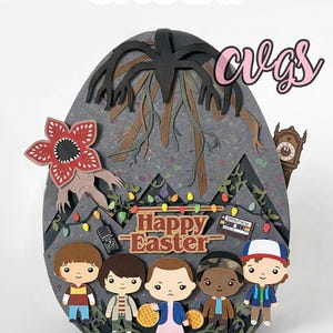 Puede incluir: Una manualidad de papel en capas con personajes y elementos de una popular serie de ciencia ficción. El diseño incluye un Demogorgon, un reloj y el texto "Happy Easter". El fondo es una forma de huevo gris con un árbol y luces.