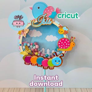 Pode incluir: Um design colorido de artesanato em papel com um pássaro azul, borboletas, uma abelha e um caracol. O design inclui o nome "Isis" e o texto "Download instantâneo". O fundo é um céu azul com nuvens e uma cerca branca.