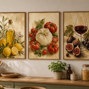 May include: A set of three rectangular wall art prints featuring watercolor-style illustrations. The first print shows a glass bottle of olive oil with lemons and leaves. The second displays a burrata cheese surrounded by red tomatoes and basil. The third depicts a glass of red wine with figs and grapes.
