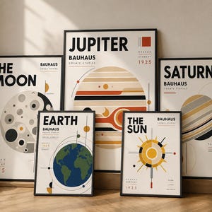 Op de afbeelding: Een collectie van vijf ingelijste posters met hemellichamen waaronder de Maan, Jupiter, de Aarde, de Zon en Saturnus. Elke print toont een grafisch ontwerp met geometrische vormen, gedempte kleuren en de tekst Bauhaus Cosmic Studies.
