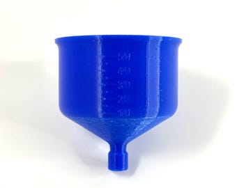 Puede incluir: Un embudo azul brillante con forma cónica y un pico estrecho. El embudo tiene marcas graduadas de 10 a 50, que indican las medidas de volumen. El producto está hecho de un material sólido y opaco.