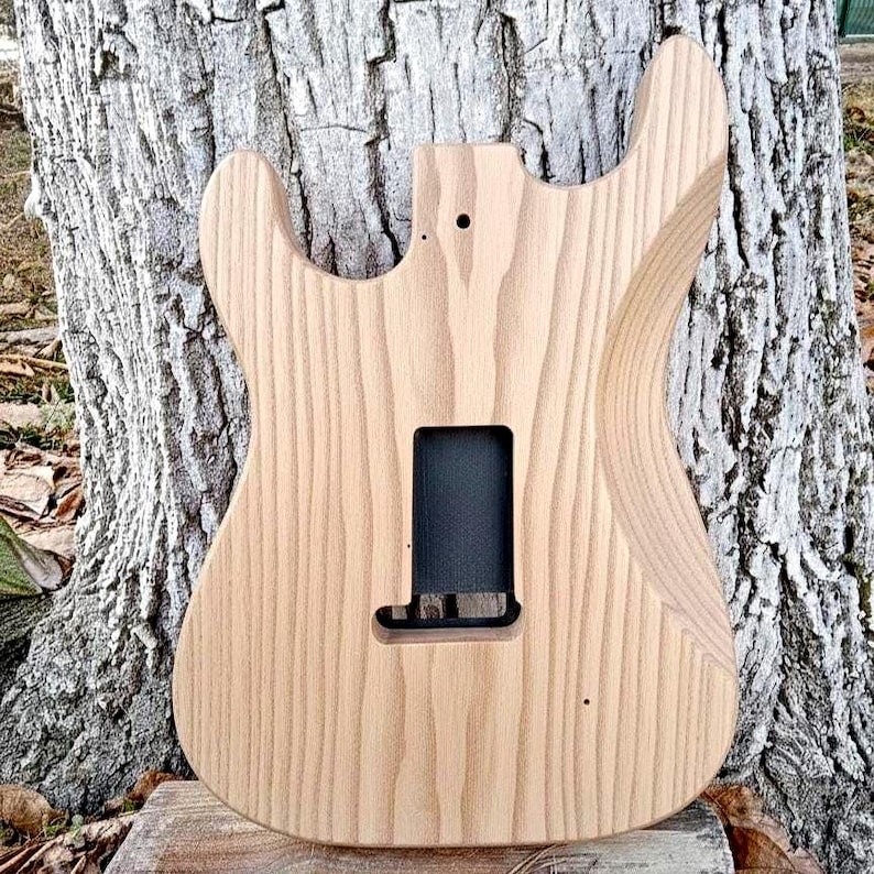 Puede incluir: Una taza de cer&aacute;mica blanca con un asa negra y el texto "But First, Coffee" en un estilo manuscrito. La taza est&aacute; sobre una superficie blanca. La taza mide aproximadamente 10 cm de alto.