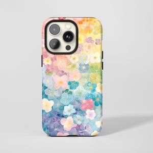 Könnte beinhalten: Eine Smartphone-Hülle mit floralem Design. Die Hülle zeigt einen Farbverlauf von Gelb nach Blau mit einem Muster aus bunten Blumen. Sie hat einen schwarzen Kameraausschnitt und Knöpfe.