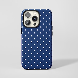 Könnte beinhalten: Eine marineblaue Handyhülle mit weißem Polka-Dot-Muster. Die Hülle hat einen schwarzen Rand um die Kamera und eine glatte, glänzende Oberfläche. Das Design ist schlicht und klassisch, passend für verschiedene Stile.