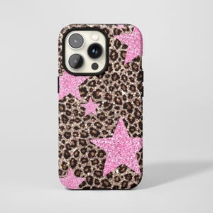 Puede incluir: Funda de teléfono con estampado de leopardo y estrellas rosas con purpurina. La funda tiene un borde negro y un recorte para la cámara. El diseño es una mezcla de estampado animal y elementos lúdicos.