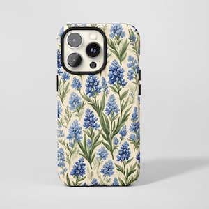 Könnte beinhalten: Eine Handyhülle mit einem floralen Muster aus blauen Lupinen. Das Design zeigt blaue Blüten und grüne Blätter auf cremefarbenem Hintergrund. Die Hülle hat einen schwarzen Rand und einen Kameraausschnitt.