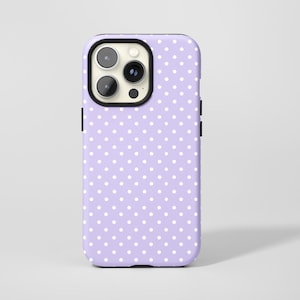 May include: A lavender phone case with a white polka dot pattern. The case has a black camera ring and black side buttons. The phone case is designed to fit a smartphone.