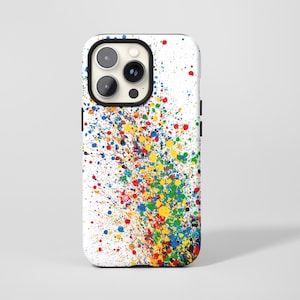 Puede incluir: Una funda blanca para teléfono con un diseño vibrante de pintura salpicada. La funda presenta un borde negro y una colorida variedad de salpicaduras de pintura en rojo, amarillo, azul y verde, creando un aspecto dinámico y artístico.