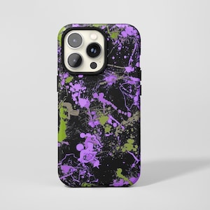 Könnte beinhalten: Eine schwarze Smartphone-Hülle mit einem lebendigen Farbspritzer-Muster in leuchtendem Violett und Limettengrün. Das Design bedeckt die gesamte Rückseite der Hülle, einschließlich des Bereichs um das Dreifach-Kameramodul oben links.