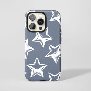 May include: A smartphone case with a pattern of white stars on a blue-gray background. The stars have a hand-drawn, brushstroke style. The case has a black camera lens surround and a black border.