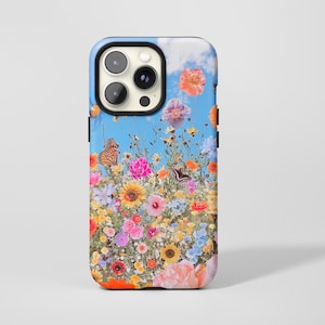 Könnte beinhalten: Eine Handyhülle mit einem lebendigen Blumendesign und Schmetterlingen vor blauem Himmel. Die Hülle zeigt eine farbenfrohe Anordnung von Blumen in Rosa, Orange, Gelb und Lila, was eine fröhliche und sommerliche Ästhetik erzeugt.