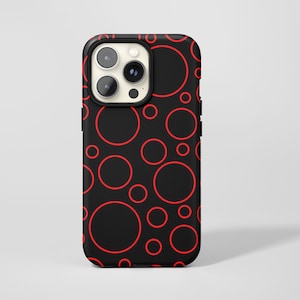Könnte beinhalten: Schwarze Handyhülle mit einem sich wiederholenden Muster aus roten Kreisen unterschiedlicher Größe. Die Hülle hat einen schwarzen Rand und einen Kameraausschnitt. Modernes und auffälliges Design.