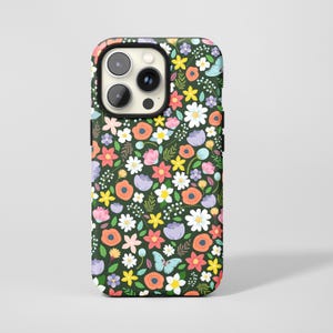 May include: A phone case with a floral pattern. The case features a dark green background covered in colorful flowers, including white daisies, orange poppies, and purple blooms. A light blue butterfly is also visible.