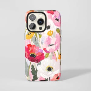 May include: A phone case with a colourful floral design. The pattern displays red, pink, yellow, and white poppies on a light background. The case has a black camera lens surround.