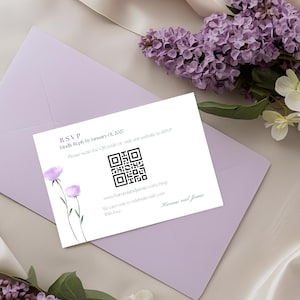 Puede incluir: Una tarjeta RSVP blanca con un código QR y detalles florales descansa sobre un sobre lavanda. La tarjeta dice "RSVP Responda amablemente antes del 01 de enero de 2027". Flores lilas y blancas en el fondo.