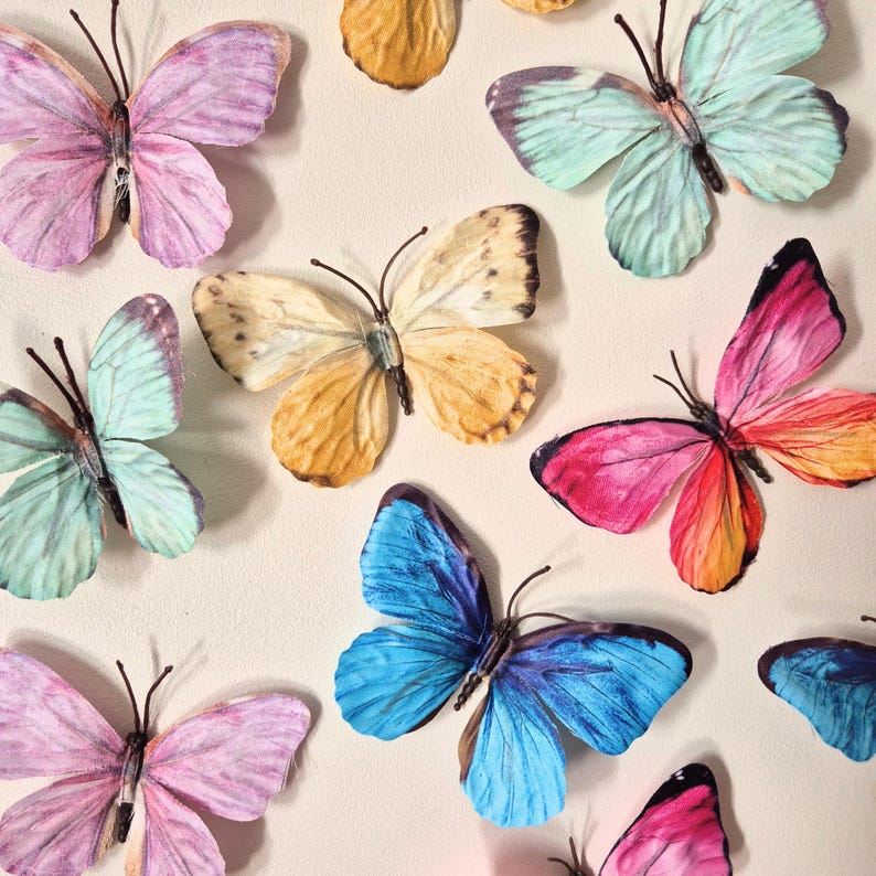 May include: An assortment of colorful butterfly decorations in shades of pink, blue, yellow, and green. The butterflies have detailed wing patterns and are arranged on a neutral background. The image showcases a variety of butterfly designs.