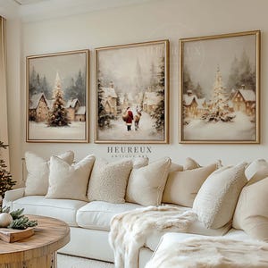 Puede incluir: Un salón acogedor con un árbol de Navidad decorado, un sofá blanco con cojines beige y tres pinturas enmarcadas de paisajes invernales. Una mesa de centro de madera con decoración navideña completa la escena.