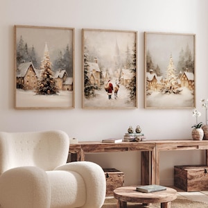 Peut inclure: Trois peintures encadrées de paysages d'hiver. Chacune présente une scène de village enneigé avec un sapin de Noël. L'œuvre d'art a une palette de couleurs douces et sourdes avec des tons chauds. Les cadres sont de couleur bois clair.