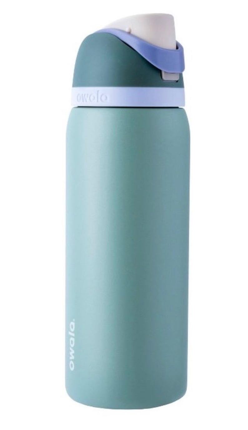 May include: A teal-colored water bottle with a white and purple lid. The bottle has the brand name "owala" printed on it. The bottle is cylindrical and appears to be made of metal or a similar material. The lid has a built-in handle.