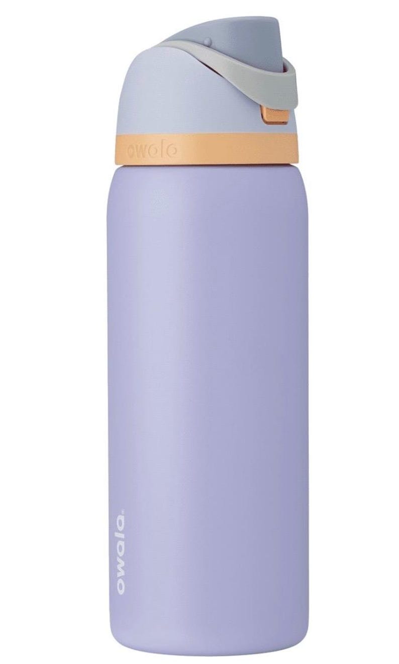 May include: A lavender-colored Owala water bottle with a light blue lid and a tan accent. The bottle has the brand name "owala" printed on the side. The lid has a gray handle and a push-button opening mechanism.