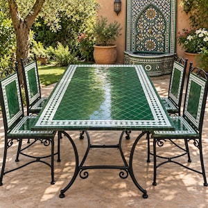 May include: A rectangular dining table and four chairs featuring green and white geometric tile patterns. The furniture set has black wrought iron frames with curved legs and matching tile inlays on the chair backs and seats.