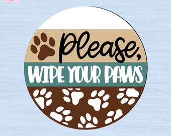 May include: A circular sign featuring a horizontal striped design in white, tan, teal, and brown. The text "Please, WIPE YOUR PAWS" is printed in black and white, accompanied by a brown paw print icon and a pattern of white paw prints at the bottom.