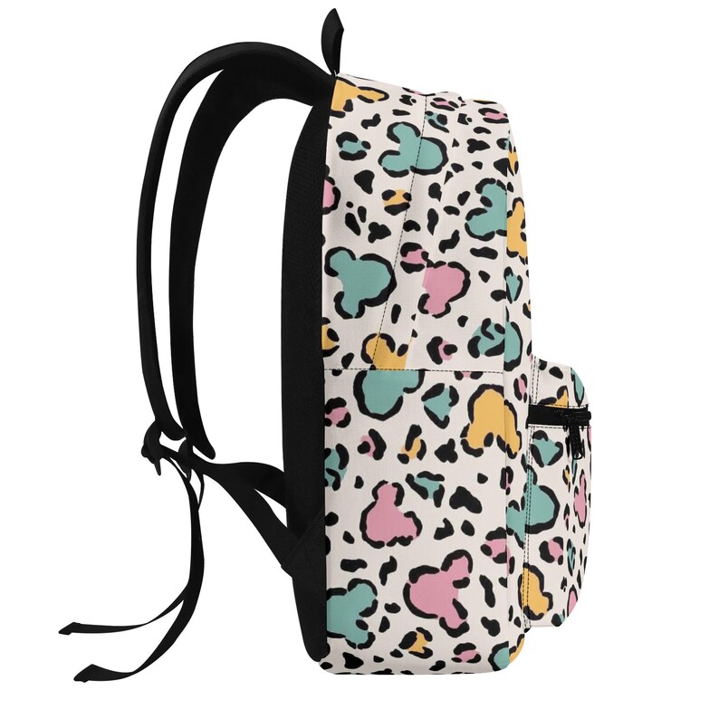K&ouml;nnte beinhalten: Ein Rucksack mit wei&szlig;em Grund und einem sich wiederholenden Muster aus schwarzen Leopardenflecken, durchsetzt mit pastellfarbenen rosa, gelben und t&uuml;rkisfarbenen Mausohr-Silhouetten. Der Rucksack hat schwarze Schultergurte, einen schwarzen Rei&szlig;verschluss und eine Vordertasche.