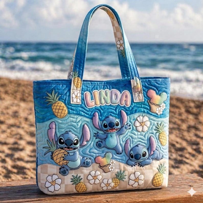 May include: Blue quilted tote bag featuring Stitch from Lilo & Stitch. The bag has a beach theme with Stitch characters, pineapples, and floral accents. The name "LINDA" is displayed on the front. The handles and bottom corners have a checkered pattern.