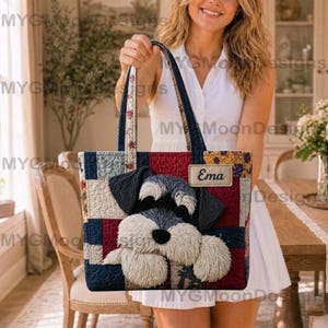 Könnte beinhalten: Eine gesteppte Tragetasche mit einem Schnauzer-Hund-Design. Die Tasche hat ein Patchworkmuster in Rot, Blau und Creme. Das Gesicht des Hundes ist deutlich sichtbar. Die Tasche hat ein Etikett mit der Aufschrift "Ema".
