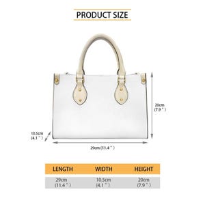 Op de afbeelding: Witte handtas met cr&egrave;mekleurige handvatten en goudkleurige hardware. De tas is 29 cm lang, 10,5 cm breed en 20 cm hoog. De tekst "PRODUCT SIZE" staat bovenaan. De afmetingen staan in een tabel.