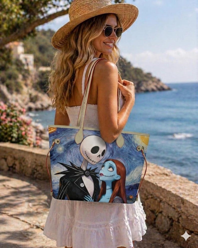 Puede incluir: Un bolso tote rectangular con un estampado gr&aacute;fico de Jack Skellington y Sally de Pesadilla antes de Navidad sobre un fondo azul de noche estrellada. El bolso cuenta con dos asas finas de color claro y herrajes en tono dorado.