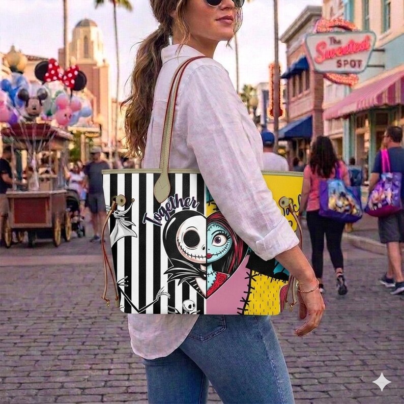 Op de afbeelding: Een tote bag met een gespleten ontwerp met zwarte en witte verticale strepen aan de ene kant en een gele achtergrond aan de andere kant. De tas toont illustraties van Jack Skellington en Sally met de tekst Together in zwarte letters.