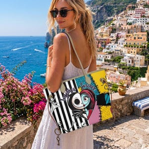 Op de afbeelding: Een tote bag met een gesplitste afbeelding van Jack Skellington en Sally uit The Nightmare Before Christmas, met de tekst Together Forever. De tas heeft zwart-witte verticale strepen, gele vlakken en lichtgekleurde schouderbanden.