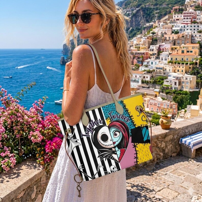 Op de afbeelding: Een tote bag met een gesplitste afbeelding van Jack Skellington en Sally uit The Nightmare Before Christmas, met de tekst Together Forever. De tas heeft zwart-witte verticale strepen, gele vlakken en lichtgekleurde schouderbanden.