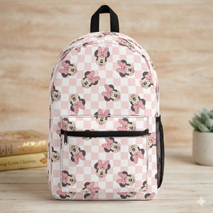 Peut inclure: Un sac &agrave; dos avec un motif r&eacute;p&eacute;titif de visages de Minnie Mouse avec des n&oelig;uds roses sur un fond &agrave; carreaux rose clair et blanc. Le sac comprend une poign&eacute;e sup&eacute;rieure, une poche avant zipp&eacute;e et une poche lat&eacute;rale en filet noir.
