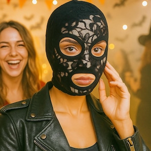 Może przedstawiać: Czarna kominiarka z koronki z otworami na oczy i usta. Kominiarka jest noszona przez osobę noszącą czarną skórzaną kurtkę. Druga osoba uśmiecha się w tle. Motyw Halloween.